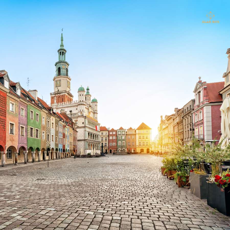 Stary Rynek w Poznaniu o wschodzie słońca z kolorowymi kamienicami i renesansowym ratuszem – punkt wyjazdu w trasach ALAN-BUS do Niemiec i Holandii
